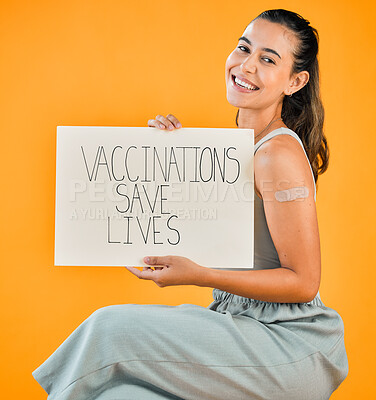 Buy stock photo Mixed race covid vaccinated woman showing plaster on arm and holding poster. Portrait of smiling hispanic woman isolated against yellow studio background with copyspace. Promote corona vaccine on sign
