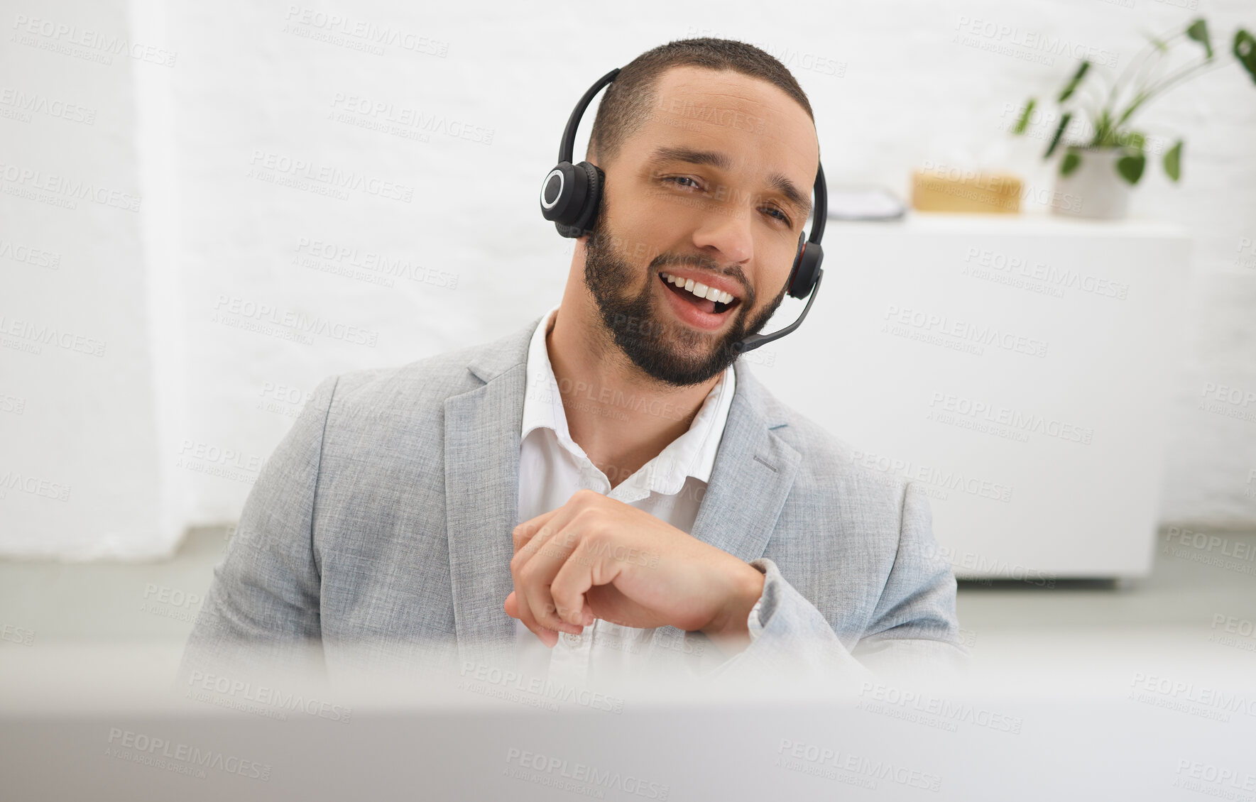 Buy stock photo Young happy mixed race male call center agent answering calls while wearing a headset at work. Hispanic businessman talking on a call while working on a desktop computer at a desk in an office