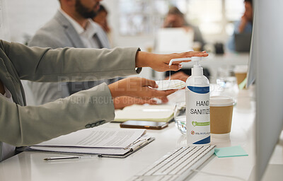 Buy stock photo Businessperson holding a tissue and using hand sanitiser from a bottle while working in an office. Business professional using sanitiser to protect from disease and infection