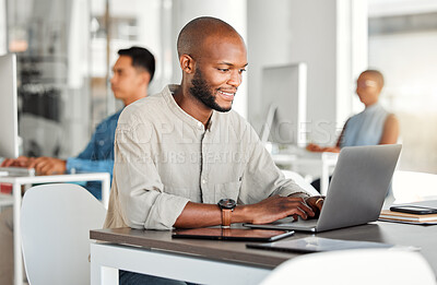 Buy stock photo Young happy african american businessman working on a laptop in an office at work. Content male businessperson typing an email at a desk. Business professional working on a computer