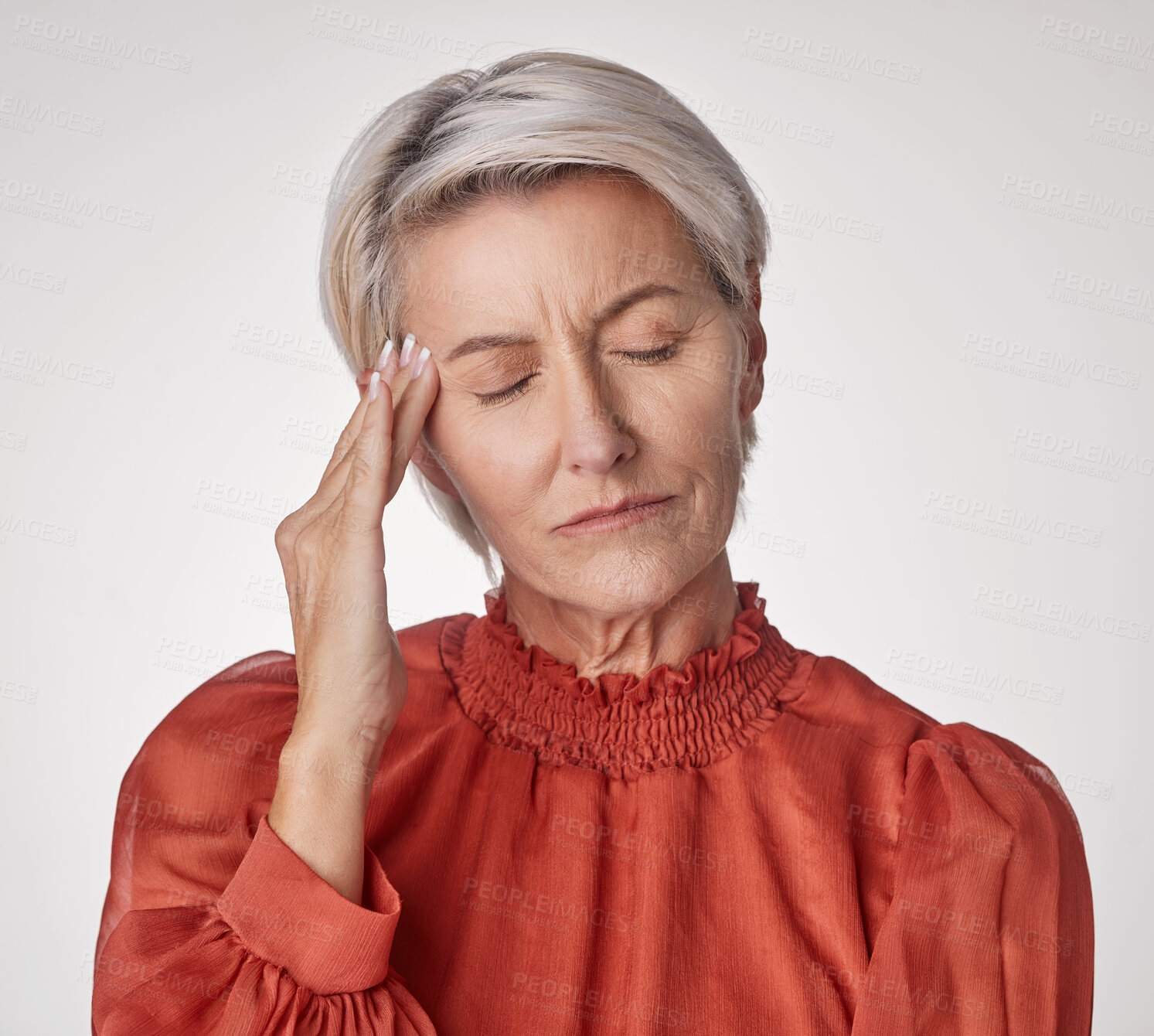 Buy stock photo One mature woman suffering with a headache and looking stressed while posing against a grey copyspace background. Ageing woman experiencing anxiety and fear in a studio