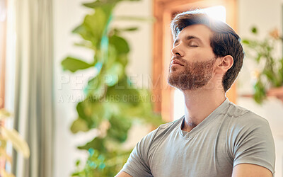 Buy stock photo One young caucasian man taking a deep breath in while practising yoga and meditating in harmony at home. Face of a calm, relaxed and focused guy feeling zen while praying quietly for stress relief and peace of mind