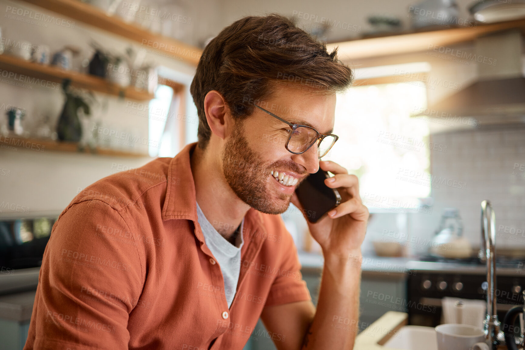 Buy stock photo Technology, man on a phone call and happy in a kitchen for remote work at his home. Smile for online communication, connectivity or social networking and male person with smartphone talking.