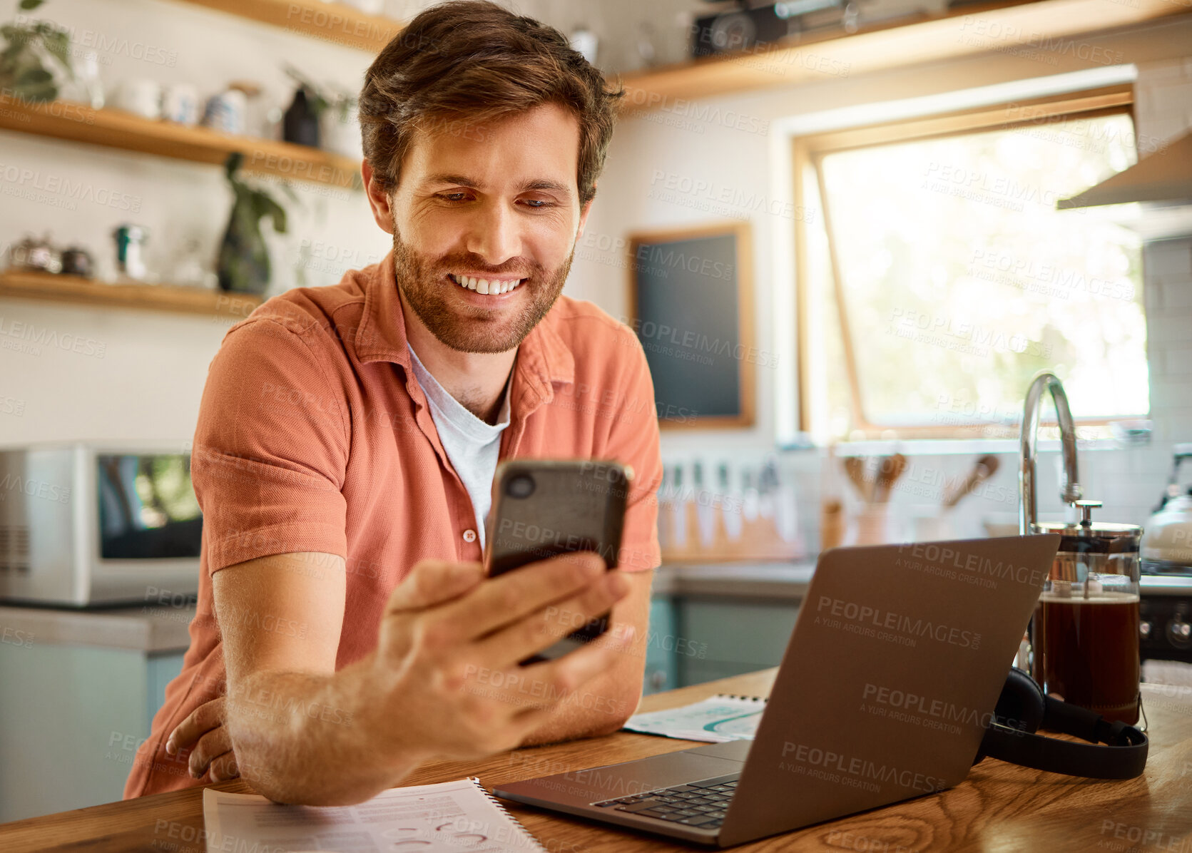 Buy stock photo Happy man, phone and chatting for social media, communication or networking on kitchen table at home. Male person with smile on mobile smartphone app for online browsing, research or texting in house