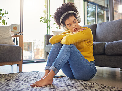 Buy stock photo African woman, sad and headphones on floor with worry, stress or memory of trauma in home living room. Gen z girl, anxiety and remember mistake, regret or mental health with music in apartment lounge