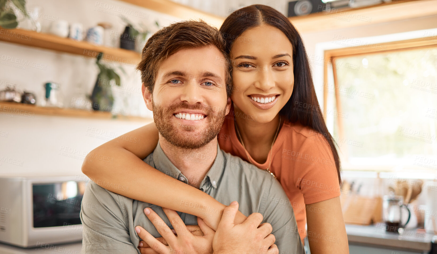 Buy stock photo Portrait of a content interracial couple bonding together at home. Joyful mixed race girlfriend embracing her caucasian boyfriend. Happy husband and wife relaxing and spending time together in the morning