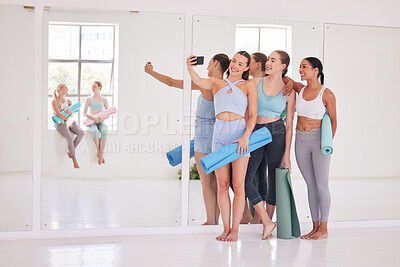 Buy stock photo Group of friends taking a selfie in yoga studio. Young women using cellphone before yoga class. Group of happy women bonding before a workout. Young friends taking a photo in yoga class