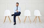 Full length of asian businessman waiting for an interview. One young impatient applicant sitting alone. Ethnic professional with arms folded in line for job opening, vacancy and opportunity in office