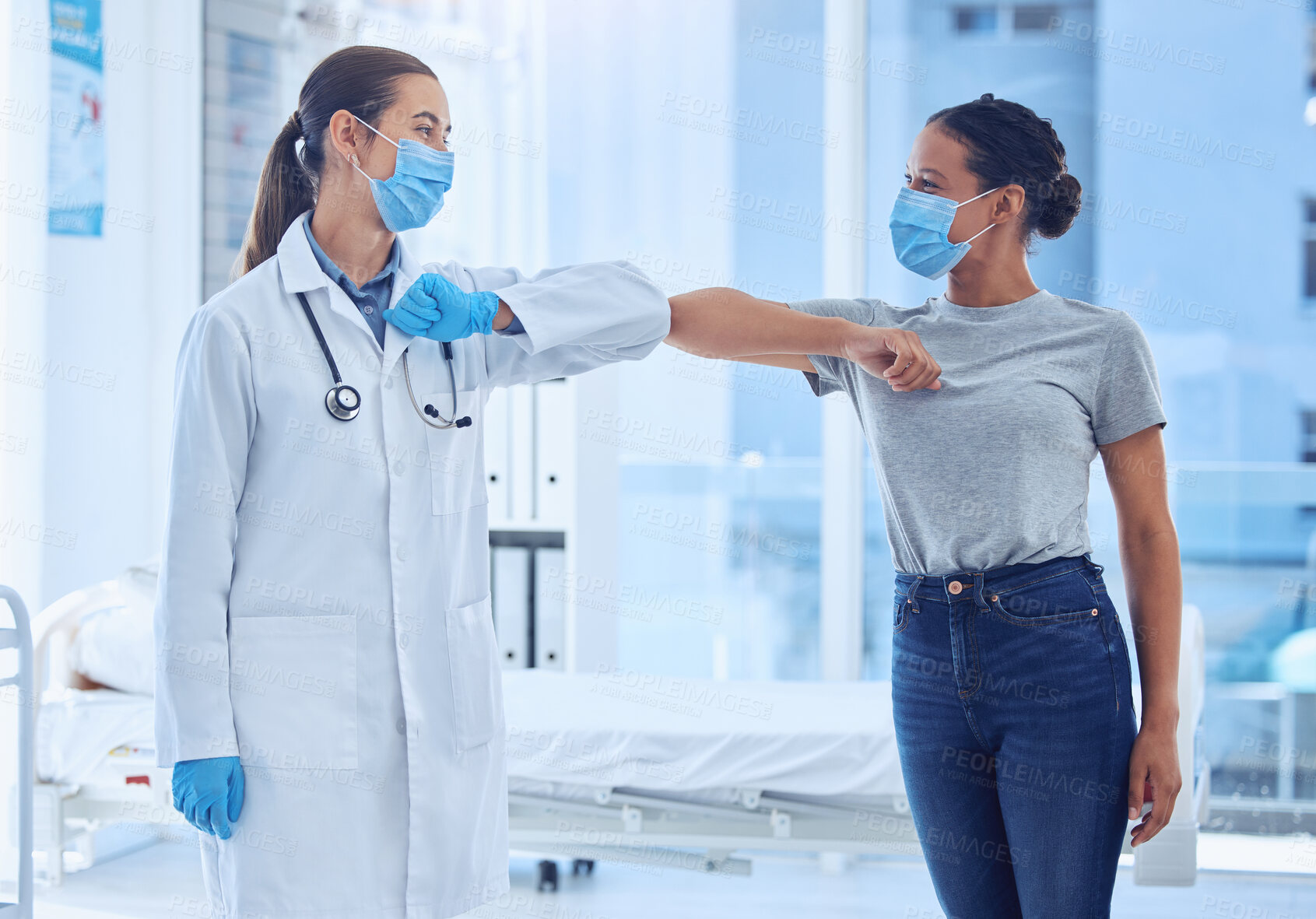 Buy stock photo Doctor greeting patient with an elbow bump. Mixed race doctor giving a patient an elbow bump in a checkup. Medical physician wearing a mask to protect from covid. Doctor and patient in consult