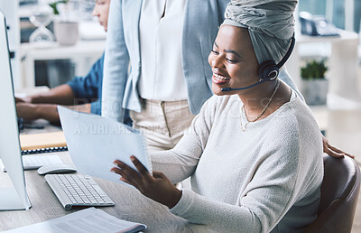 Buy stock photo African american call centre telemarketing agent reading paperwork while receiving training and assistance from supervisor in an office. Confident female consultant troubleshooting solution with manager. Colleagues operating helpdesk together