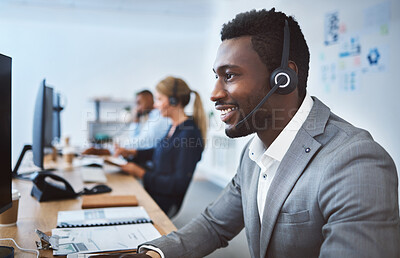 Buy stock photo Happy young african american call centre telemarketing agent talking on a headset while working on computer in an office. Confident friendly male consultant operating helpdesk for customer service and sales support