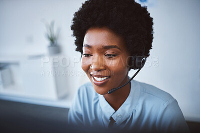 Buy stock photo One happy young african american call centre telemarketing agent talking on a headset while working on computer in an office. Face of confident friendly female consultant operating helpdesk for customer service and sales support