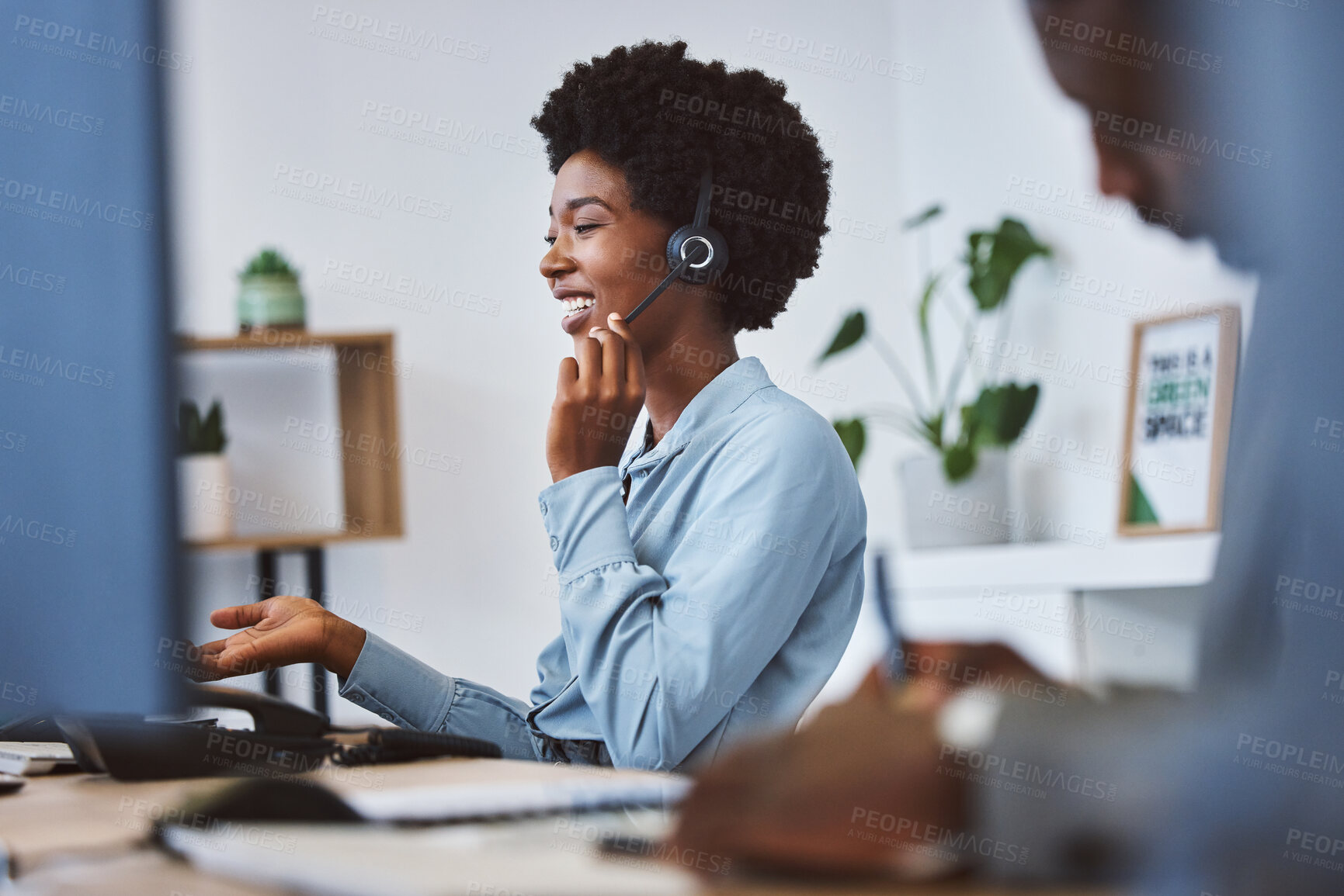 Buy stock photo Happy young african american call centre telemarketing agent talking on a headset while working on computer in an office. Confident friendly female consultant operating helpdesk for customer service and sales support