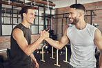 Cheerful athletes greeting each other. Fit bodybuilders collaborate on training together. Strong athletes saying hello in the gym. Confident workout partners make a deal in the gym