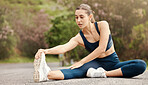 One fit young mixed race woman touching her feet and stretching legs for warmup to prevent injury while exercising outdoors. Female athlete preparing body and muscles for training workout or run at the park