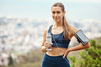 Buy stock photo Portrait of woman with earphones, drink water and hiking with fitness app in nature for health and wellness. Music, bottle and girl on mountain with phone for workout with radio streaming or podcast.