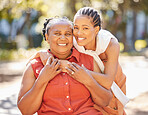 Portrait happy mature woman and her adult daughter spending quality time together in the park during summer. Beautiful young woman and her mother bonding outdoors. A senior lady and her adult child