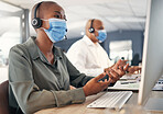 African american call centre telemarketing agent wearing face mask as health and safety protocol talking on headset while using computer in an office. Female consultant operating helpdesk for customer service and sales support during covid pandemic