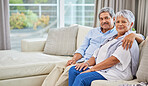 Portrait of an affectionate mixed race senior couple relaxing in their living room at home. Hispanic man and wife  bonding on the sofa in the living room being affectionate