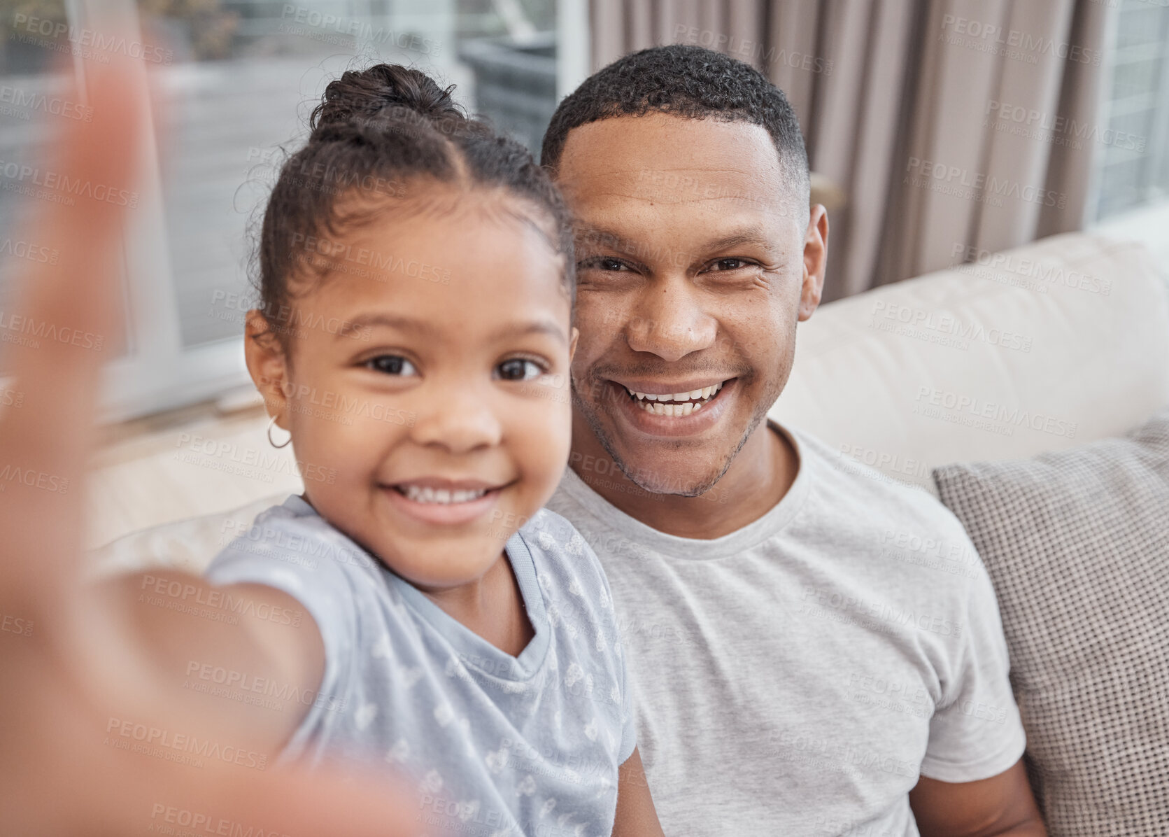 Buy stock photo Handsome young mixed race man and his cute daughter taking a selfie photograph at home. Father and his girl child bonding and taking pictures in the living room. a single parent and his female kid