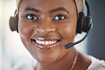 Closeup portrait of one happy african american call centre telemarketing agent with big smile talking on headset while working in office. Face of confident friendly female consultant operating helpdesk for customer service and sales support