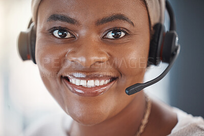 Closeup portrait of one happy african american call centre telemarketing agent with big smile talking on headset while working in office. Face of confident friendly female consultant operating helpdesk for customer service and sales support