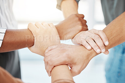 Closeup of diverse group of people holding each other\'s wrists in a circle to express unity, support and solidarity. Connected hands of multiracial community linked for teamwork in a huddle. Society join together for collaboration and equality