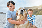 Portrait of two cute little boys playing with their pet golden retriever at the beach. Cheerful kids having fun while rubbing loyal furry brown dog outdoors