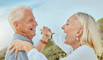 Buy stock photo A happy mature caucasian couple enjoying fresh air on vacation at the beach. Smiling retired couple dancing outside