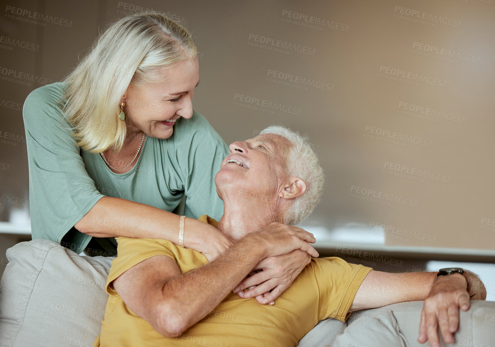 Buy stock photo Happy elderly couple bonding and enjoying retirement together. Senior caucasian man and woman being affectionate on a sofa at home