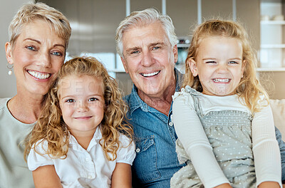 Buy stock photo Portrait of two little girls spending time with their grandparents on a sofa at home . Mature caucasian couple babysitting their grandchildren on the weekend