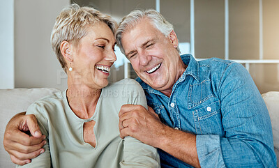 A happy relaxed mature retired couple talking and laughing together in the living room. Smiling caucasian couple bonding on the sofa at home