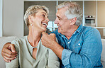 A happy relaxed mature retired couple talking and laughing together in the living room. Smiling caucasian couple bonding on the sofa  at home