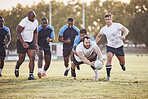 Caucasian rugby player diving to score a try during a rugby match outside on a field. Young male athlete making a dive to try and win the game for his team. Young man reaching out for the try line