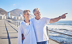 A happy mature caucasian couple enjoying fresh air on vacation at the beach. Smiling retired couple getting a cardio workout while walking outside