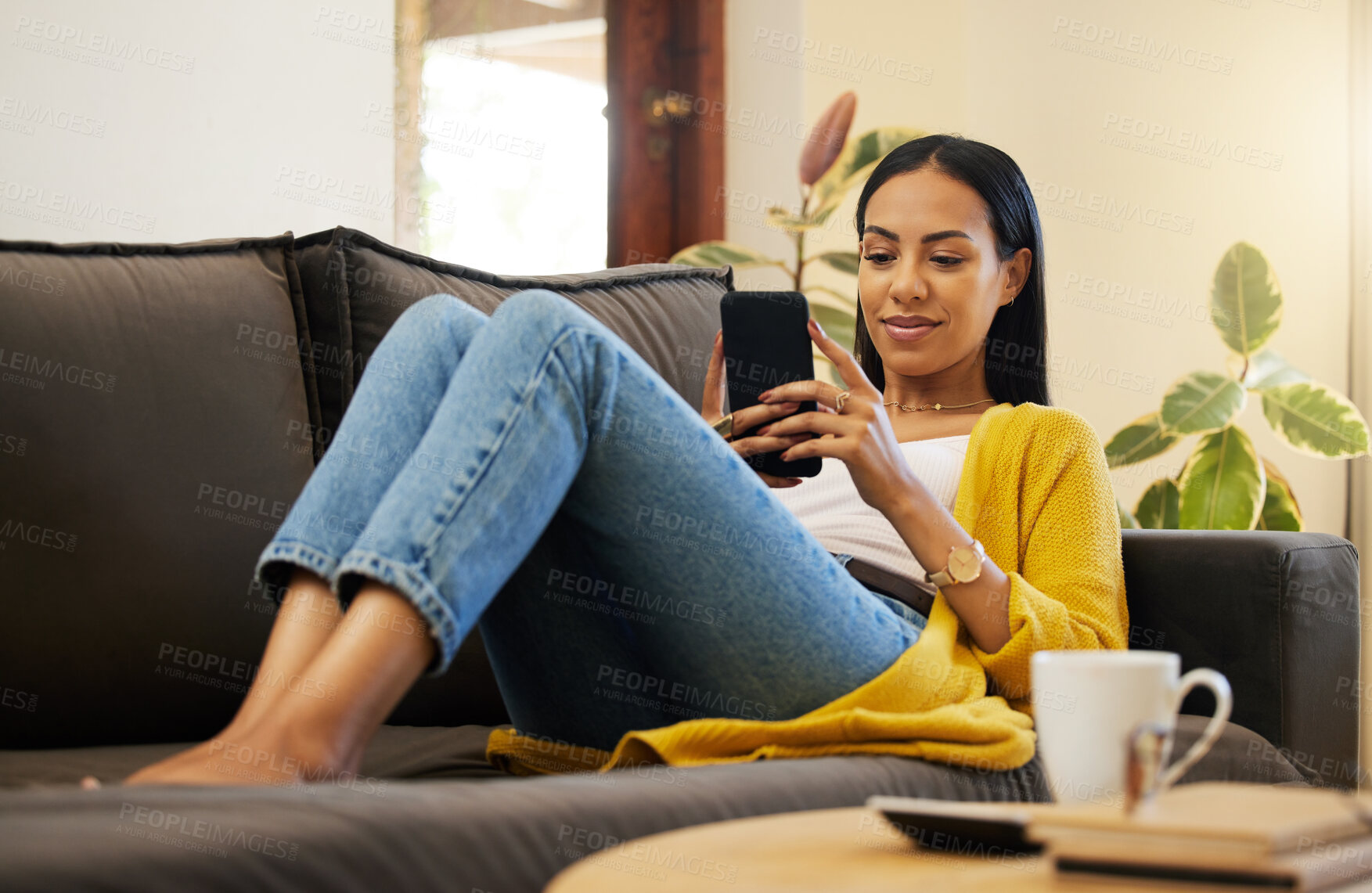 Buy stock photo Relax, social media and a woman with a phone on the sofa for communication, notification and chat. Content, sitting and girl reading the internet, message or text message on a mobile on the couch