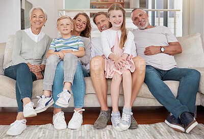 Buy stock photo Portrait of a happy family sitting on the couch in the living room at home. Joyful little girl and boy bonding with parents and grandparents in the living room. Grandparents visiting grandchildren