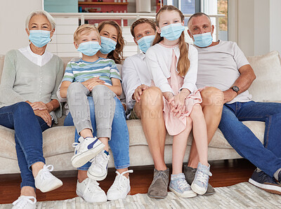 Portrait of happy generational caucasian family wearing face masks while relaxing on sofa at home. Kids, parents and grandparents staying responsible and safe from ill health during covid pandemic