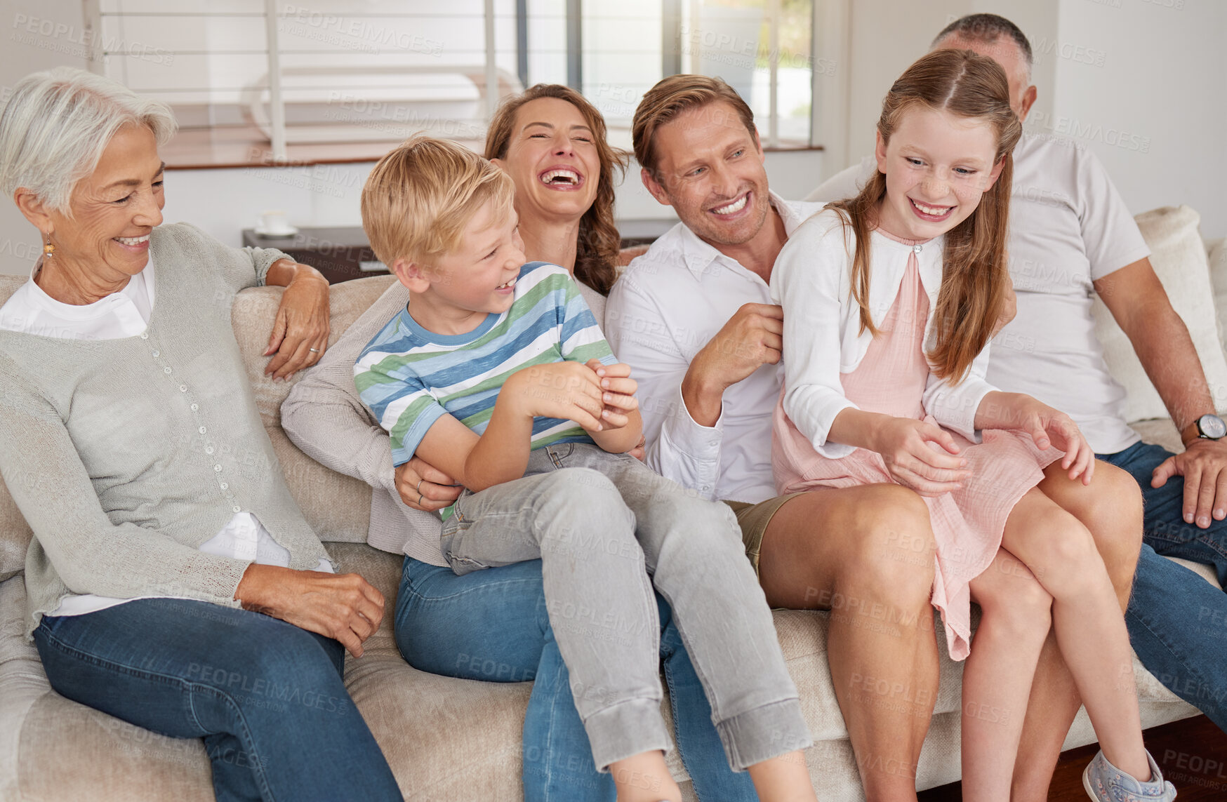 Buy stock photo Portrait of a happy family laughing and sitting on the couch in the living room. Little girl and boy bonding with parents and grandparents in the living room. Grandparents visiting the grandchildren