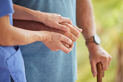 Buy stock photo A nurse and senior patient holding hands while helping him to walk outside. Closeup of an elderly man being supported by female caregiver while walking to improve his mobility,  health, and wellbeing