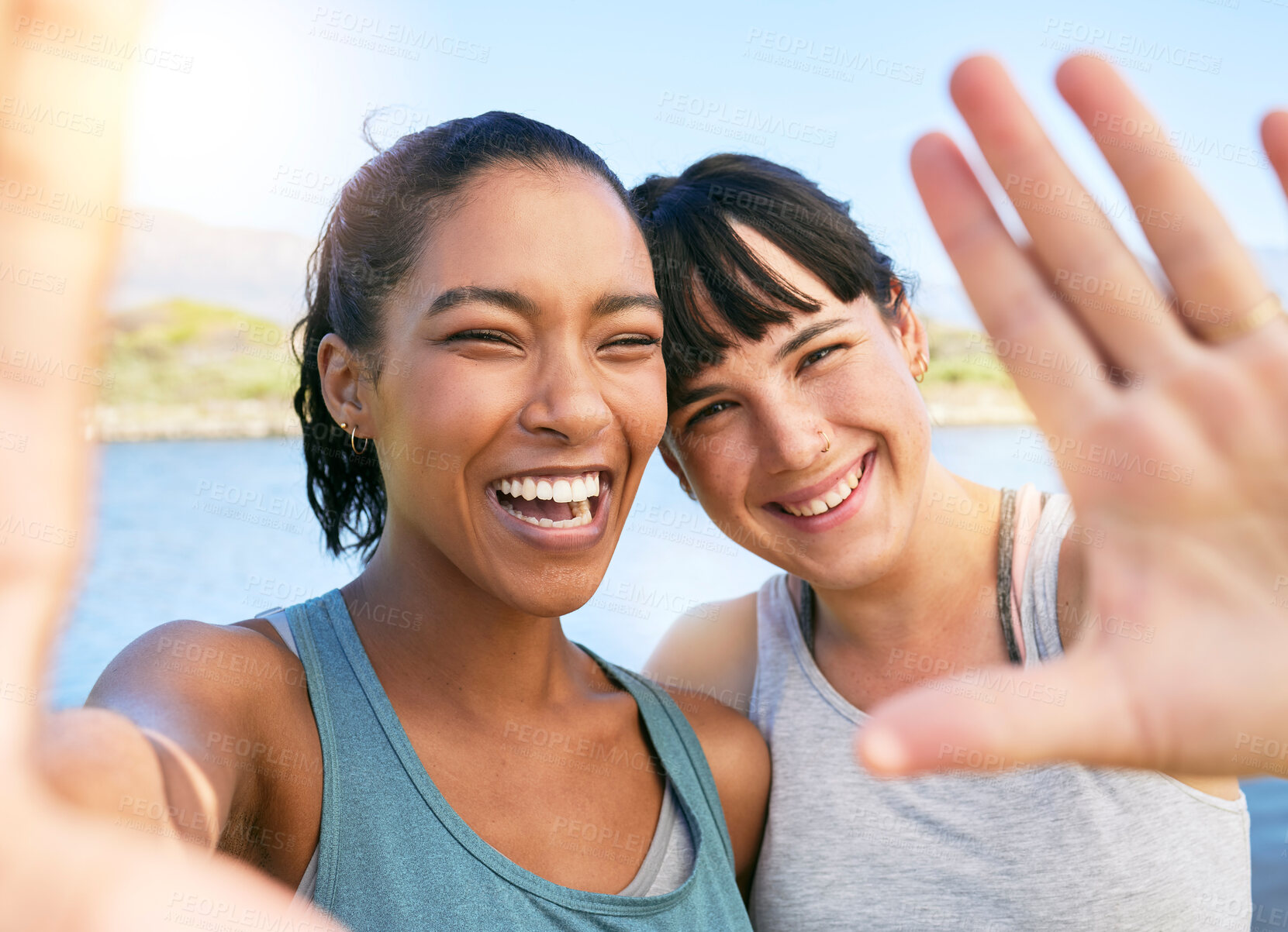 Buy stock photo Portrait of two smiling friends taking selfies together for social media on a lake over summer break. Smiling happy women bonding and hugging outside in nature. Embracing and having fun on weekend