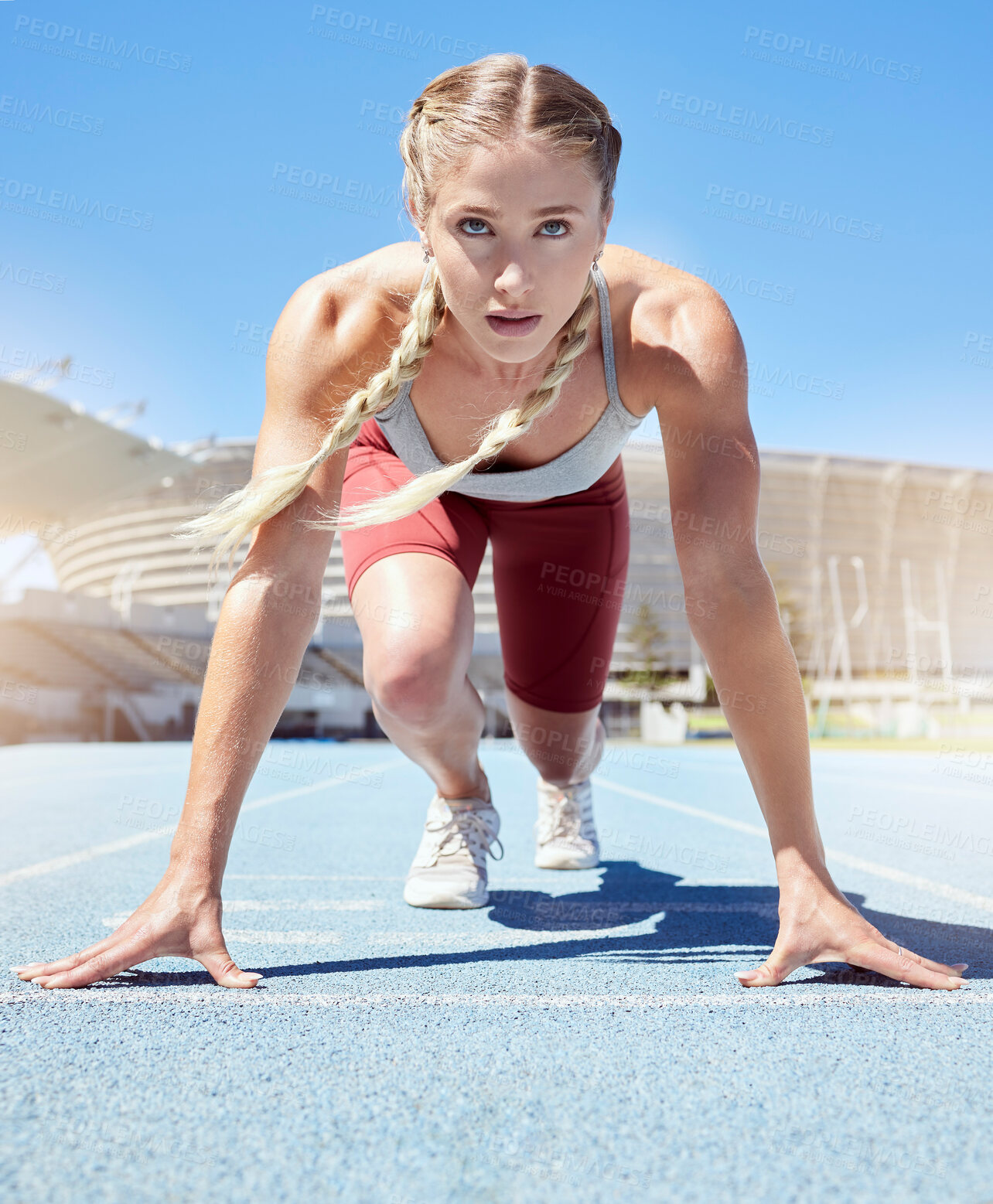 Buy stock photo Serious female athlete at the starting line in a track race competition at the stadium. Fit sportswoman mentally and physically prepared to start running at the sprint line or starting block