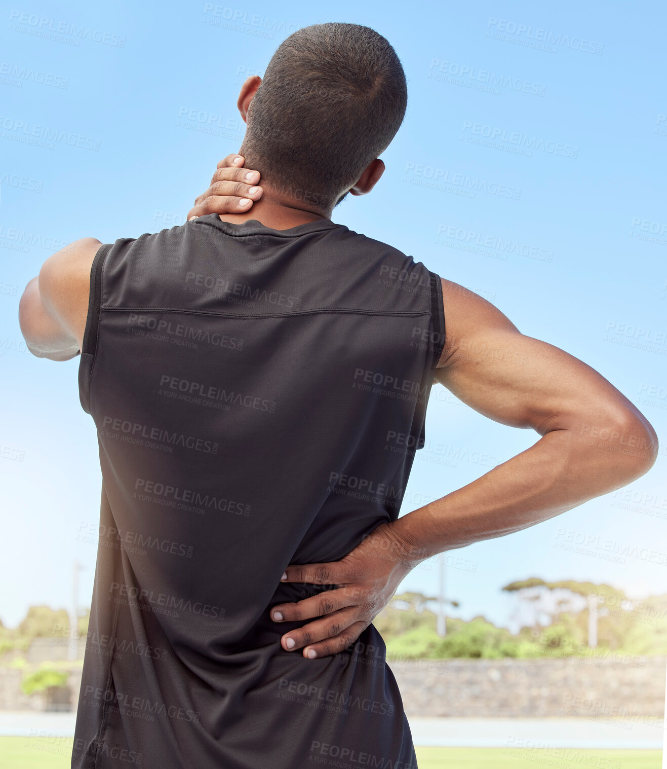 Buy stock photo Rearview of athlete with neck pain. Closeup back view of an uncomfortable young sportsman standing on a sport field holding his stiff and inflamed joints. Muscle strain due to injury