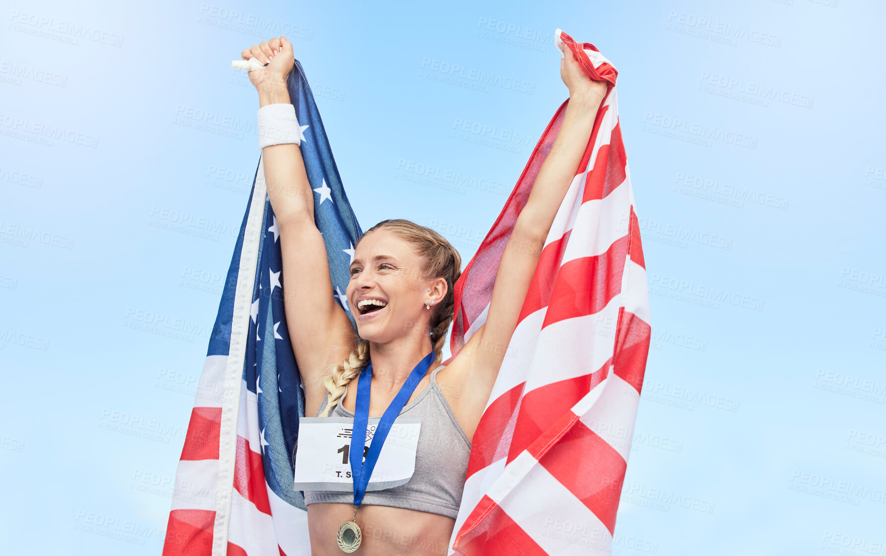 Buy stock photo Young fit female athlete cheering and holding American flag after competing in sports. Smiling fit active sporty woman feeling motivated and celebrating achieving gold medal in olympic sport