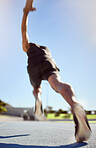 Rearview of unknown track runner sprinting in outdoor training practice. Below view of fit active man running with speed and motion blur. Athlete exercising in workout for cardio health and stamina