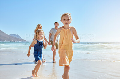 Buy stock photo Joyful young family with two children running on the beach and enjoying a fun summer vacation. Two energetic little girls having a race while their mother and father follow in the background