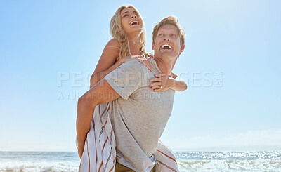 Buy stock photo A young loving couple having fun with a piggyback ride, enjoying a day at the beach while smiling hugging and showing at the ocean. Romantic man carrying his wife on his back while on vacation