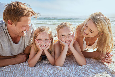 Buy stock photo Portrait of a carefree family relaxing and bonding on the beach. Two cheerful little girls spending time with their mother and father on holiday. Mom and dad admiring their daughters on vacation
