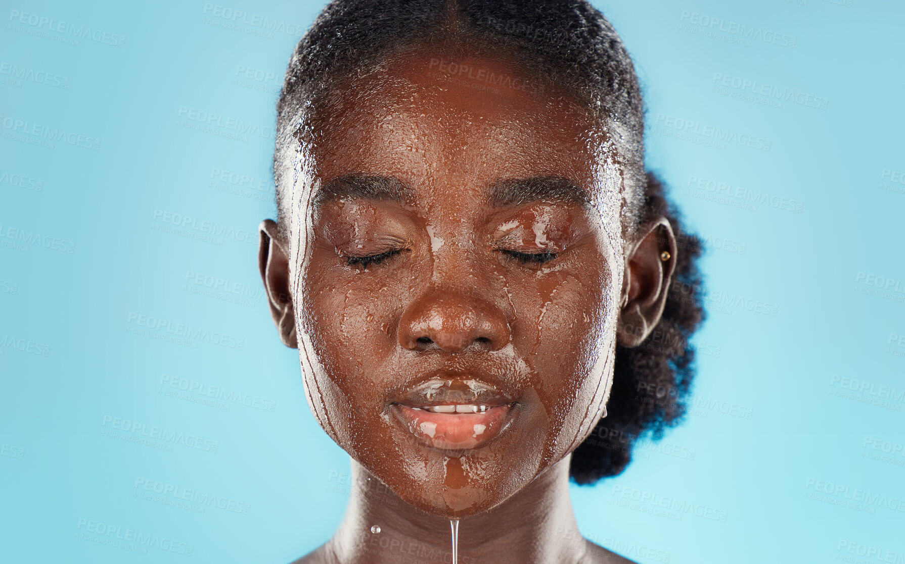 Buy stock photo Water, skincare and face of a black woman in studio for health, wellness and self care with dermatology cosmetic care. African model on blue background cleaning or detox skin for beauty facial