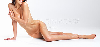 Buy stock photo Shot of a young woman posing nude against a gray background